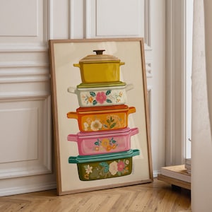 Puede incluir: Una lámina artística vertical enmarcada que muestra una pila de cinco ollas y sartenes rectangulares y ovaladas en colores amarillo, crema, naranja, rosa y verde. Cada recipiente está decorado con ilustraciones florales y asas laterales.