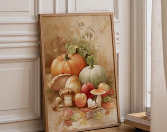 May include: A framed watercolor print featuring a still life composition of an orange pumpkin, a pale green pumpkin, red apples, and various mushrooms. The arrangement includes scattered autumn leaves and greenery on a warm, neutral background.