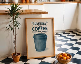 Może przedstawiać: Prostokątny obraz w ramie z beżowym tłem i ciemnoniebieską ilustracją kubka do kawy z pokrywką. Tekst głosi: Sometimes I like COFFEE more than people. Wydruk umieszczony jest w jasnej drewnianej ramie o prostym, klasycznym wykończeniu.