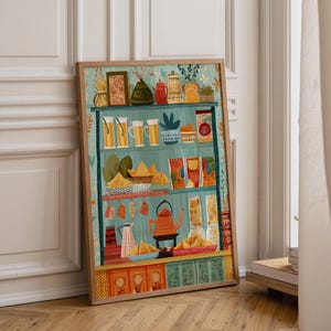 Op de afbeelding: Een ingelijste muurkunstprint met een kleurrijke illustratie van een keukenplank. De planken staan vol met diverse voorwerpen, waaronder een rode theepot, glazen potten, kommen met eten en bakjes met patronen tegen een lichtblauwe achtergrond.