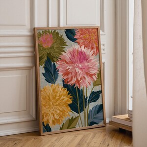 May include: A rectangular framed wall art print featuring a botanical illustration of large dahlia flowers in shades of pink, orange, and yellow. The flowers are set against a light blue textured background with dark blue and green leaves.