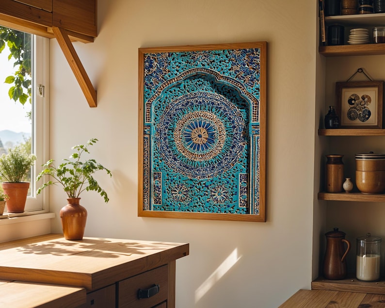 May include: A framed artwork with an elaborate design in teal and gold. The artwork has a detailed circular pattern at its centre. The wooden frame surrounds the artwork. The piece is displayed in a kitchen, adding a touch of artistic flair to the space.