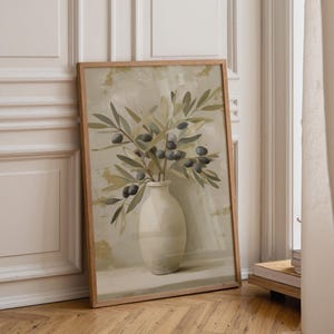 May include: A framed art print depicting olive branches in a white vase. The artwork uses a neutral colour palette with greens, greys, and beige. The wooden frame complements the artwork's natural theme, creating a calming aesthetic.