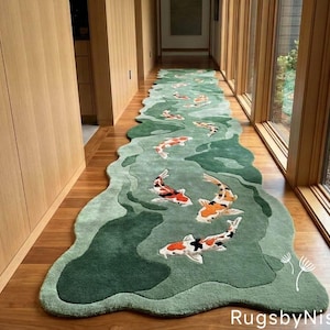 May include: A long, green, wavy rug with a koi fish design. The rug features a pond-like pattern with various shades of green and detailed koi fish in orange, white, and black. The rug is placed on a wooden floor in a hallway.