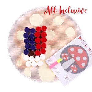 May include: A round, all-inclusive punch needle kit with a red, white, and blue design. The kit includes a needle, a pattern, and a variety of colorful yarn pieces. The text "All Inclusive" is written in red cursive.