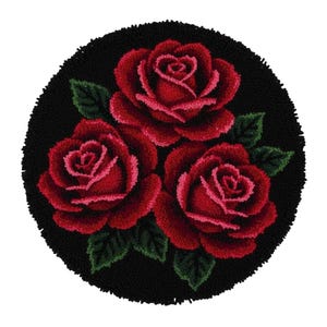 Op de afbeelding: Een ronde, zwarte vloerkleed met drie rode rozen en groene bladeren. De rozen zijn gedetailleerd met verschillende tinten rood, wat een textuur geeft. De rand van het vloerkleed is een donkerder, getextureerd zwart.