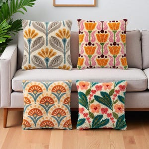 Peut inclure: Quatre coussins carrés avec une broderie à l'aiguille perforée texturée. Le coussin en haut à gauche présente un motif floral gris et jaune. Celui en haut à droite affiche des tulipes orange à tiges roses. En bas à gauche, des motifs en éventail orange, et en bas à droite, des feuilles vertes avec des fleurs roses et orange.