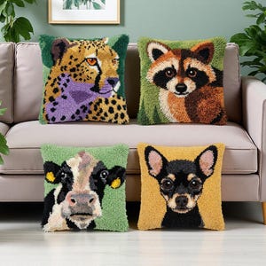 May include: Four decorative cushions with animal designs. The cushions feature a cheetah, raccoon, cow, and a dog. The cheetah cushion has a purple and yellow design. The raccoon cushion has a brown and black design. The cow cushion has a black and white design. The dog cushion has a black and yellow design.