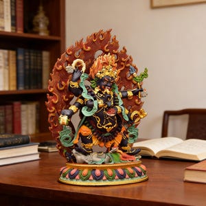 May include: A detailed statue of a deity with a fierce expression, featuring multiple arms and intricate details. The figure is predominantly black with accents of gold, red, and green, set against a backdrop of stylized flames. The statue rests on a colorful, ornate base.