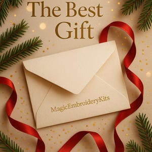 K&ouml;nnte beinhalten: Cremefarbener Umschlag mit goldfarbenem Text "The Best Gift" und "MagicEmbroideryKits". Rotes Band und Tannenzweige im Hintergrund, die eine festliche Atmosph&auml;re erzeugen.
