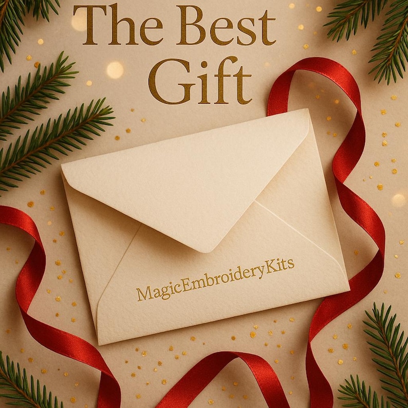 K&ouml;nnte beinhalten: Cremefarbener Umschlag mit goldfarbenem Text "The Best Gift" und "MagicEmbroideryKits". Rotes Band und Tannenzweige im Hintergrund, die eine festliche Atmosph&auml;re erzeugen.