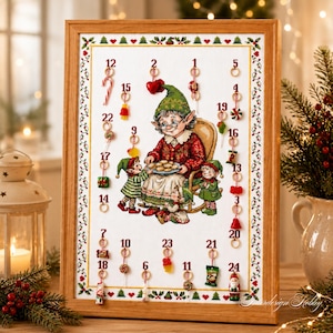 Peut inclure: Un calendrier de l'Avent de Noël encadré avec une illustration au point de croix représentant un elfe âgé assis dans un fauteuil à bascule avec deux plus petits elfes. Le tissu blanc affiche les chiffres 1 à 24, chacun avec un petit ornement.
