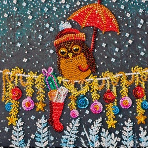 May include: A beaded owl wearing a Santa hat and holding a red umbrella, with a Christmas stocking and presents. The background is dark with a snowy effect, and a garland of ornaments hangs below.