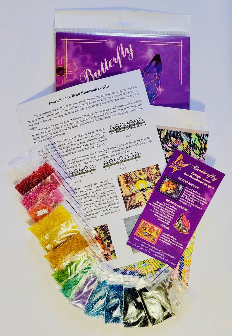 K&ouml;nnte beinhalten: Perlenstick-Set mit Anleitung und einer lila Verpackung mit der Aufschrift "Butterfly". Das Set enth&auml;lt kleine Beutel mit bunten Perlen, ein gedrucktes Muster und ein Faltblatt mit Diagrammen. Das Set ist f&uuml;r die Perlenstickerei konzipiert.