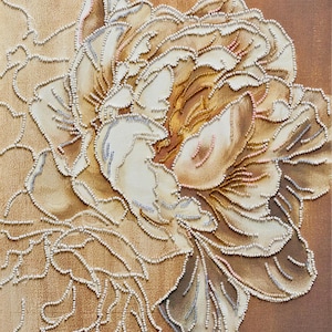 以下が含まれることがあります： 大きな質感のある花を特徴とする花の芸術作品のクローズアップ。 花びらはクリーム、タン、ゴールドのブレンドで、小さな真珠のようなビーズで縁取られています。 背景は茶色のグラデーションで、奥行き感があります。