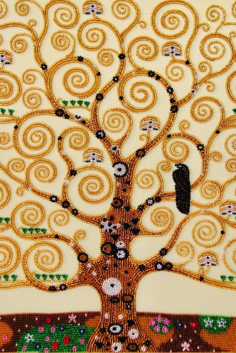 K&ouml;nnte beinhalten: Nahaufnahme eines Perlenkunstwerks, das einen stilisierten Baum mit goldenen Spiralzweigen und einem braunen Stamm darstellt. Der Baum ist mit schwarzen und wei&szlig;en Akzenten und kleinen, pilzartigen Details verziert. Der Hintergrund ist hellbeige.