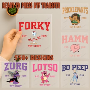 May include: A collection of ready-to-press DTF transfer designs featuring characters from the Toy Story franchise. Designs include Forky, Hamm, Zurg, Lotso, Bo Peep, and Pricklepants. The image also includes the text "550+ DESIGNS".