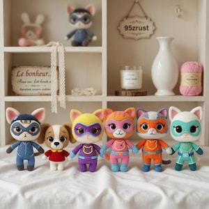 May include: A collection of handmade crochet superhero cat dolls in various colors, including blue, yellow, orange, and teal. Each doll has a unique mask and costume. A dog doll is also included. The dolls are displayed on a white shelf.