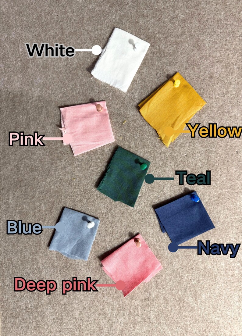 May include: A collection of fabric swatches in various colors, including white, pink, yellow, teal, blue, deep pink, and navy. Each swatch is pinned to a neutral surface and labeled with its corresponding color name.