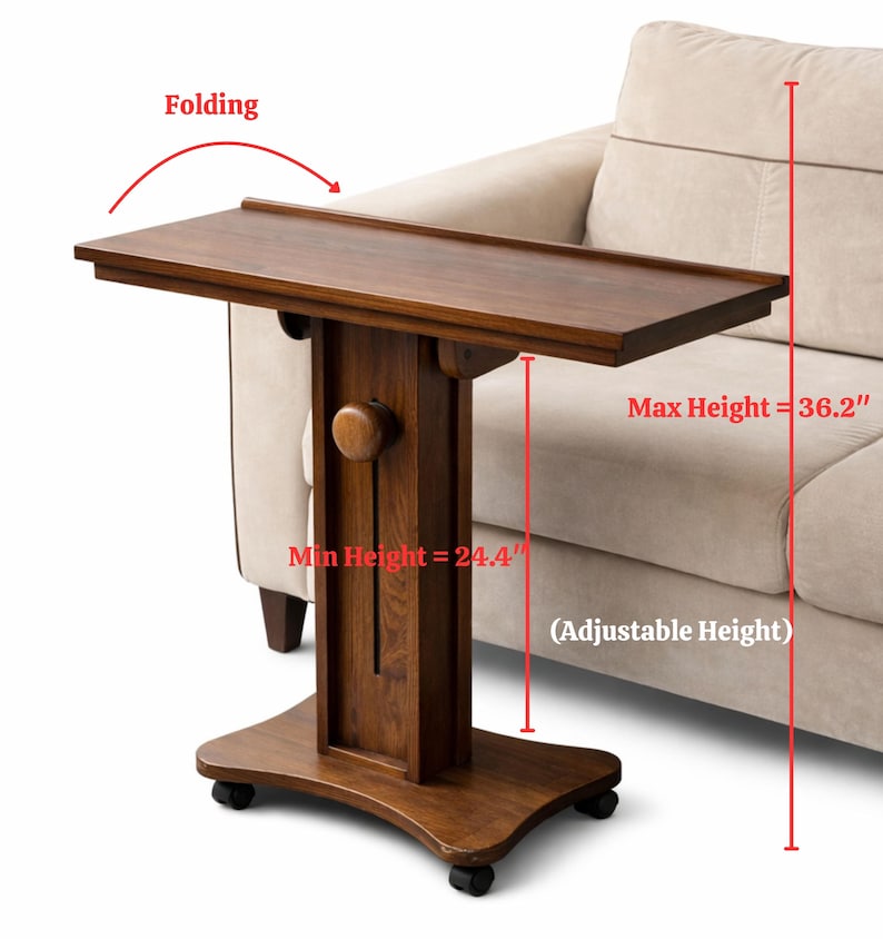 May include: A brown wooden folding side table with adjustable height. The table has a maximum height of 36.2 inches and a minimum height of 24.4 inches. It is on wheels and is positioned next to a beige sofa.