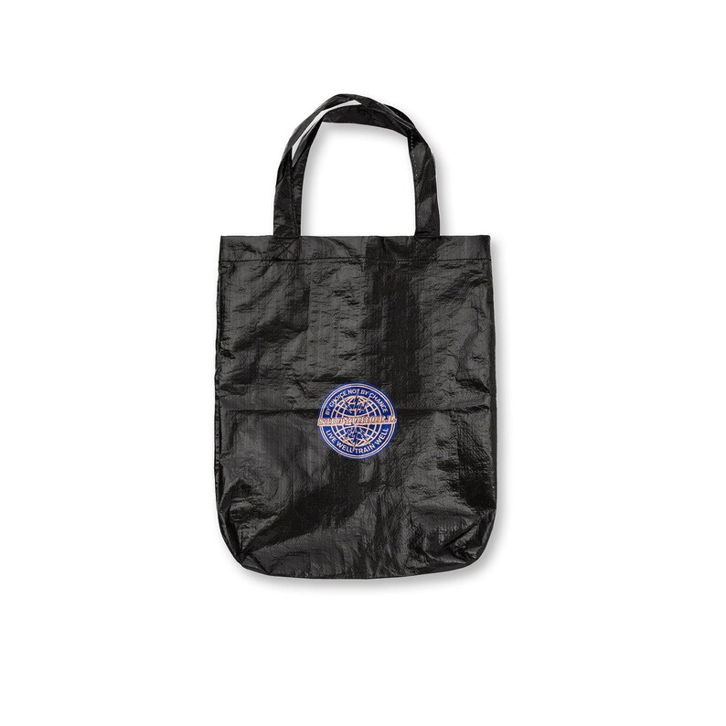 May include: Black tote bag with a circular patch featuring text and a globe design. The bag has two handles and is made of a textured material. The patch is blue, white, and orange.