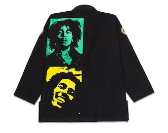 May include: Black jacket featuring two Bob Marley portraits in green and yellow. The jacket has a round collar and long sleeves. A green, yellow, and red emblem is on the right shoulder. The jacket is made of a soft, comfortable material.