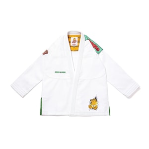 May include: A white martial arts gi jacket featuring a Garfield character graphic on the lower front, a green Garfield patch on the shoulder, and a yellow and black striped interior lining. The garment includes green side vents and text.