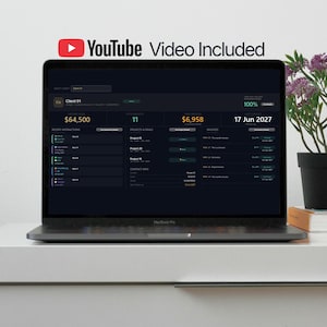 Puede incluir: Un ordenador portátil que muestra un panel de control de tema oscuro con datos financieros, incluidos números de interacciones recientes, proyectos y facturas. La pantalla también muestra el texto "YouTube Video Included". El portátil está sobre una superficie blanca.