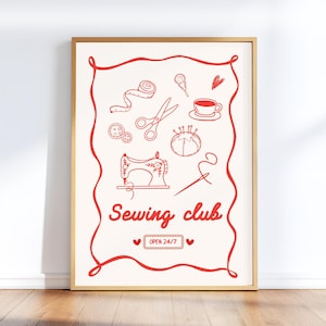 May include: A framed print with a gold border features red line drawings of sewing tools and a sewing machine on an off-white background. The words "Sewing club" are written in red script, with "OPEN 24/7" below.