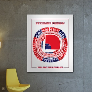 May include: A vintage-style illustration of Veterans Stadium, home of the Philadelphia Phillies. The stadium seating chart is shown in red and blue colors. The text "Veterans Stadium" and "Philadelphia Phillies" is printed on the white background.
