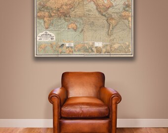Puede incluir: Un mapa del mundo vintage cuelga sobre un sillón de cuero marrón en una habitación con suelo de madera.