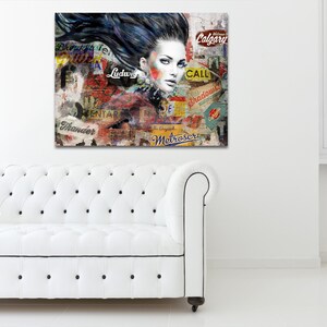 Könnte beinhalten: Ein Leinwandkunstdruck mit einer Frau mit dunklem Haar und auffälligem Make-up. Das Kunstwerk enthält Collage-Elemente mit Text und Grafiken im Vintage-Stil in einer Mischung aus Farben, darunter Rot, Gelb und Weiß. Der Druck wird über einem weißen Sofa angezeigt.