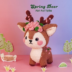 Puede incluir: Un peluche de ciervo tejido a ganchillo en color marrón y crema con una corona de flores rosas y hojas verdes en la cabeza, astas de color marrón oscuro y mejillas rosadas. El texto Spring Deer PDF PATTERN aparece en la parte superior.