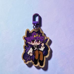 May include: An acrylic keychain featuring a cartoon character with purple hair, pointed ears, and a small yellow crown. The character wears a white shirt, black vest, and brown pants, holding a purple spear. It has a purple metal lobster clasp.