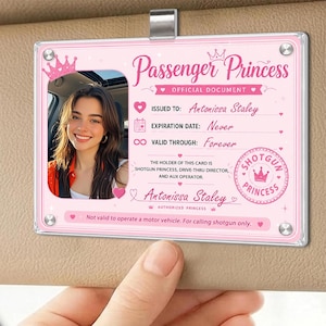 May include: A rectangular pink Passenger Princess official document card featuring a photo of a smiling person, the name Antonissa Staley, and text stating expiration is never and valid through forever, with a Shotgun Princess stamp and crown icon.