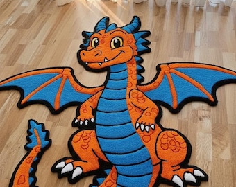 Könnte beinhalten: Ein orangefarbener, blauer und schwarzer Drachenteppich. Der Teppich zeigt einen freundlichen Drachen mit einem lächelnden Gesicht, Flügeln und einem langen Schwanz. Der Teppich liegt auf einem Holzboden.