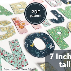 Pode incluir: Uma coleção de letras de tecido com vários padrões florais e botânicos em tons de verde, amarelo, rosa e azul escuro. Cada letra tem uma borda recortada. Um emblema circular diz PDF pattern e o texto indica 7 Inches tall.