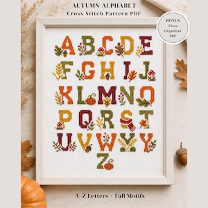 Puede incluir: Un patrón de punto de cruz enmarcado con el alfabeto de otoño, cada letra decorada con motivos otoñales como hojas, calabazas y setas. El texto "AUTUMN ALPHABET" y "A-Z Letters + Fall Motifs" es visible.