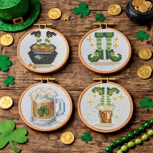 以下が含まれることがあります： 聖パトリックの日のテーマが施された、4つの丸いクロスステッチフープ。デザインには、金のポット、緑のレプラコーンの足、クローバーの入ったビールジョッキ、金のポットが含まれます。金貨、クローバー、緑の帽子がフープを囲んでいます。