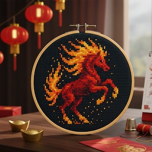 May include: A cross-stitch embroidery hoop featuring a fiery horse design in shades of red and yellow against a black background. The hoop is set against a backdrop of red lanterns and gold ingots, evoking a festive theme.