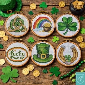 May include: Six St Patrick's Day cross-stitch embroidery hoops with wooden frames. Designs include a shamrock, rainbow with pot of gold, horseshoe, leprechaun hat, and the word "Lucky". Gold coins and green shamrocks are scattered around.