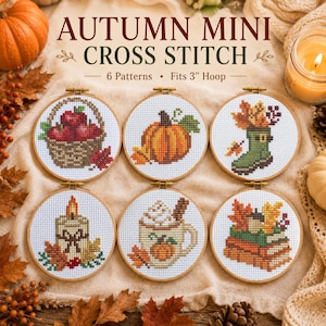 Può includere: Sei telai da ricamo circolari in legno contenenti motivi a punto croce a tema autunnale. I disegni includono un cesto di mele, una zucca, uno stivale con foglie, una candela, una tazza con panna montata e libri con una ghianda.