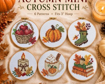 May include: Six circular wooden embroidery hoops containing autumn-themed cross stitch patterns. Designs include a basket of apples, a pumpkin, a rain boot with leaves, a candle, a mug with whipped cream, and a stack of books with an acorn.