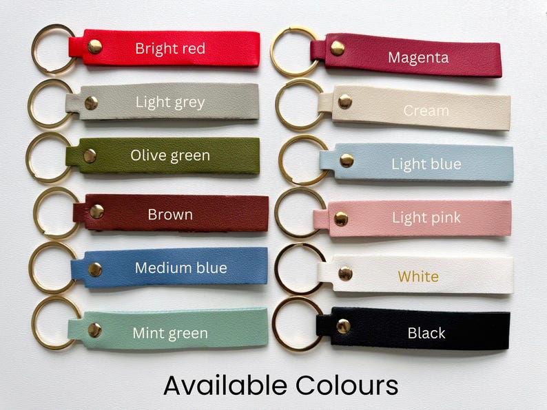 May include: A collection of leather keychains in various colors, including bright red, light grey, olive green, brown, medium blue, mint green, magenta, cream, light blue, light pink, white, and black. Each keychain has a gold-colored ring and the text "Available Colours".