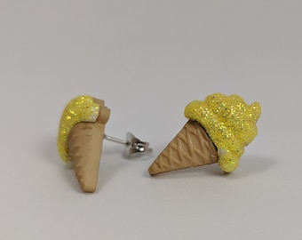 May include: A pair of yellow glitter ice cream cone earrings. The earrings are made of polymer clay and have silver posts.