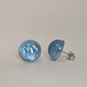 May include: A pair of light blue stud earrings with a silver post.