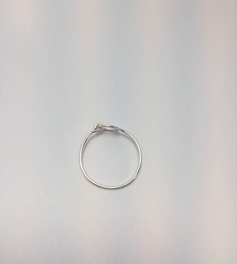 以下が含まれることがあります： 上部に小さなボールが付いたシルバーのフープイヤリング