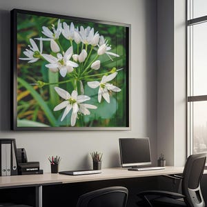 Könnte beinhalten: Ein gerahmter Druck mit weißen Wildblumen und grünem Laub hängt über einem Schreibtisch. Die Büroumgebung umfasst einen Computer, Büromaterial und einen schwarzen Stuhl. Das Fenster bietet einen Blick auf eine Stadtlandschaft.