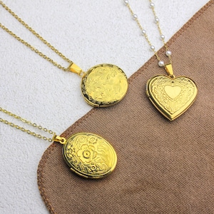May include: Three gold-colored lockets with intricate floral and heart designs. The lockets are on delicate chains, one with a pearl strand. The lockets are round, oval, and heart-shaped, perfect for holding small photos or keepsakes.