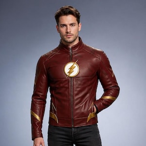 Könnte beinhalten: Burgunderfarbene Lederjacke mit goldenem Blitz-Emblem auf der Brust und goldenen Akzenten an Ärmeln und Taschen. Die Jacke wird mit schwarzen Jeans und schwarzen Turnschuhen kombiniert. Die Jacke hat einen Reißverschluss und einen Stehkragen.